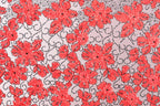 a repeating pattern of red flowers with black swirls against a light gray background.