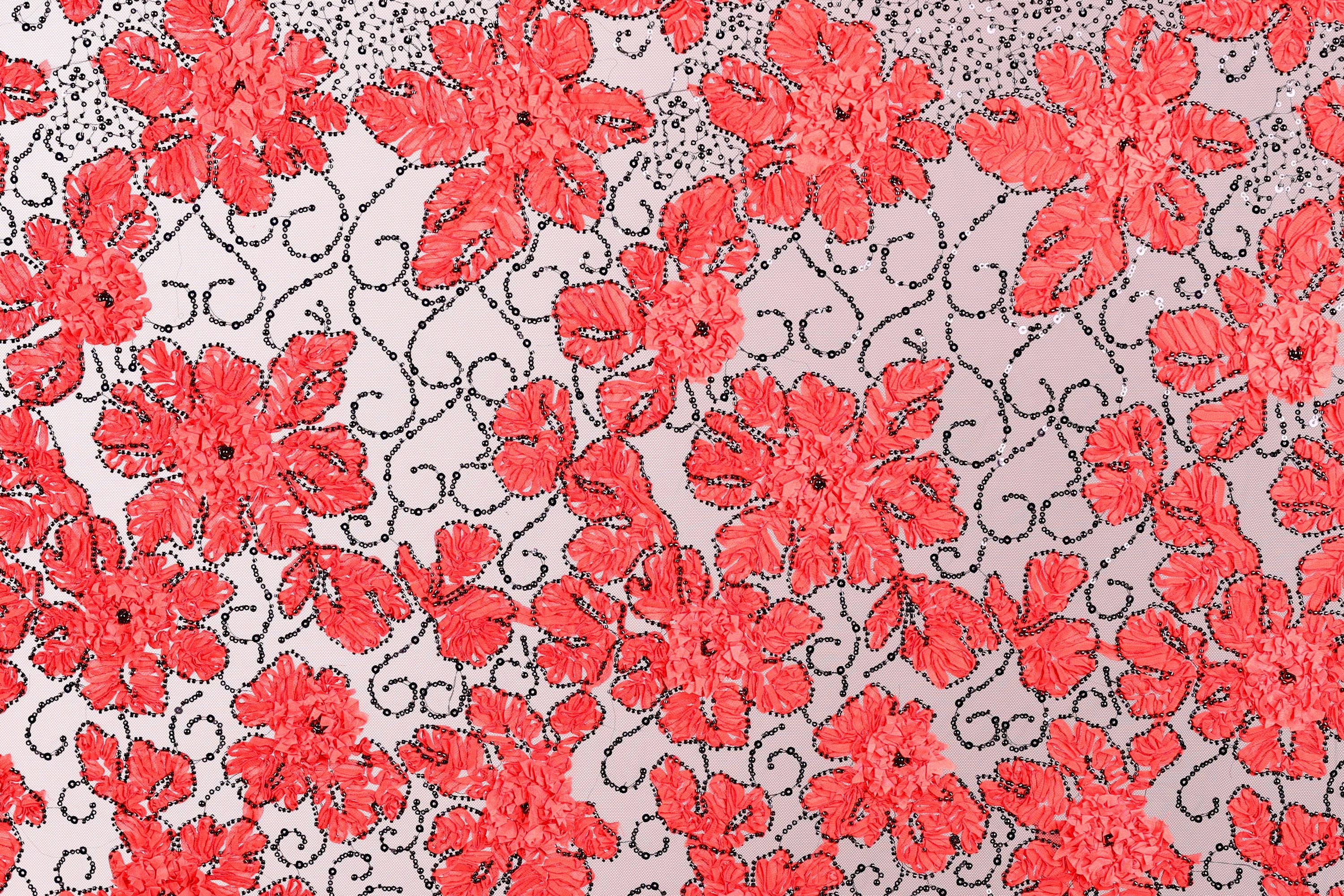a repeating pattern of red flowers with black swirls against a light gray background.