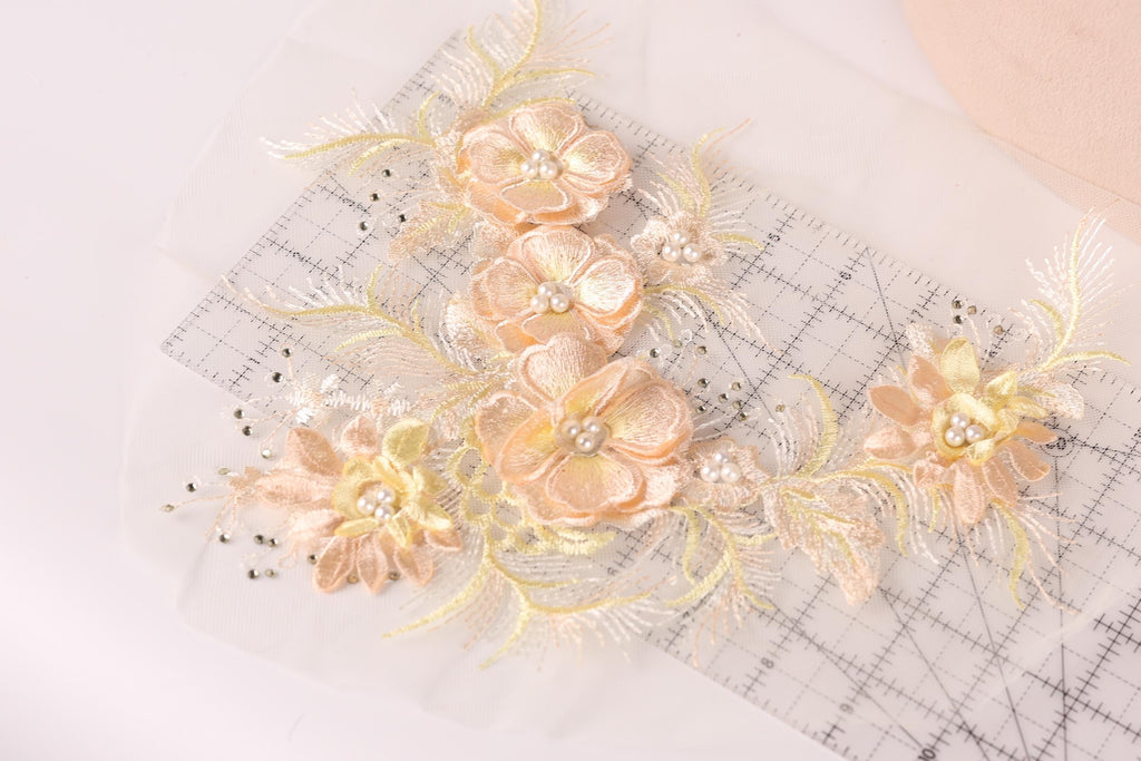 a close-up view of delicate, intricately embroidered flowers on a transparent background.