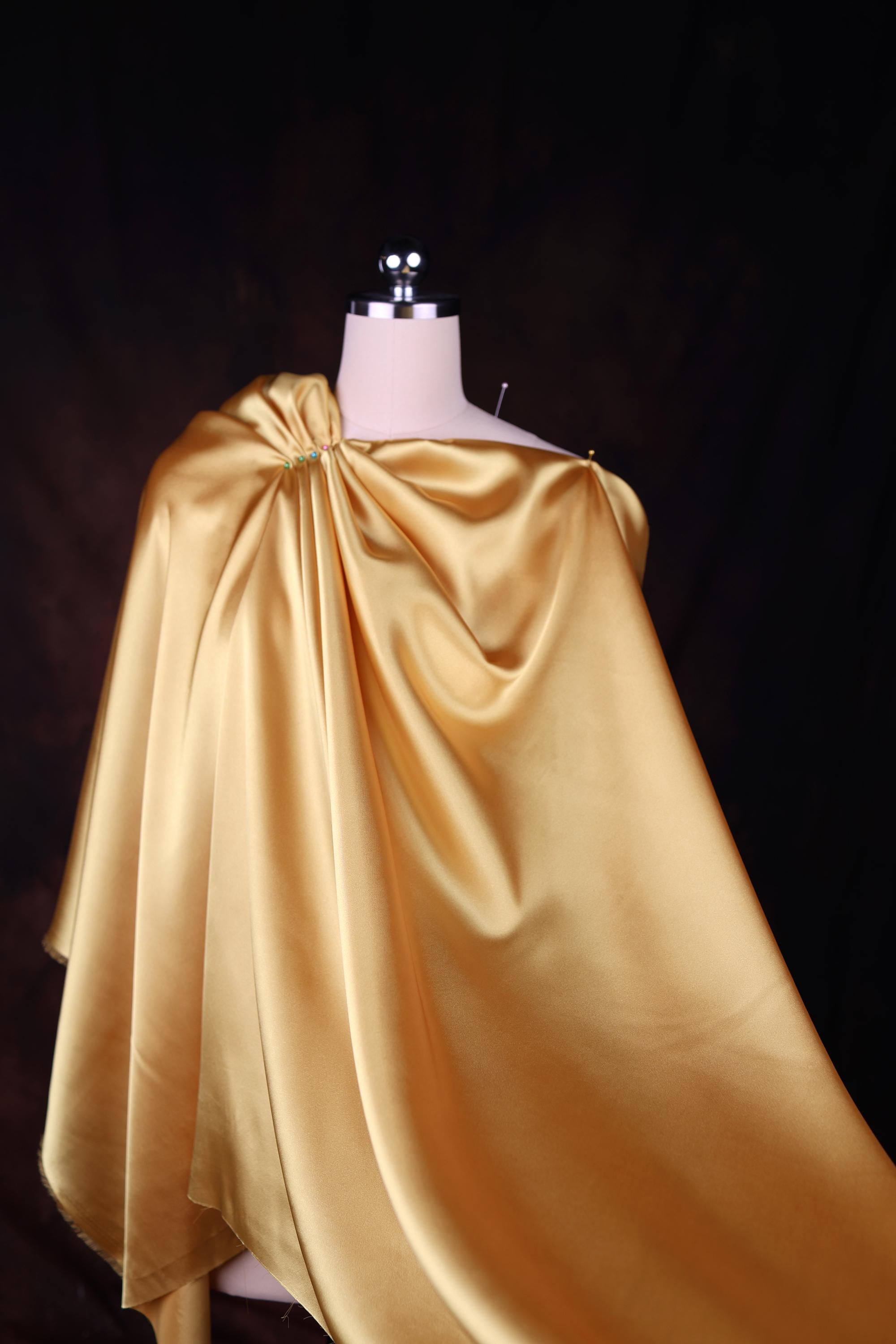 a mannequin dressed in a gold cape