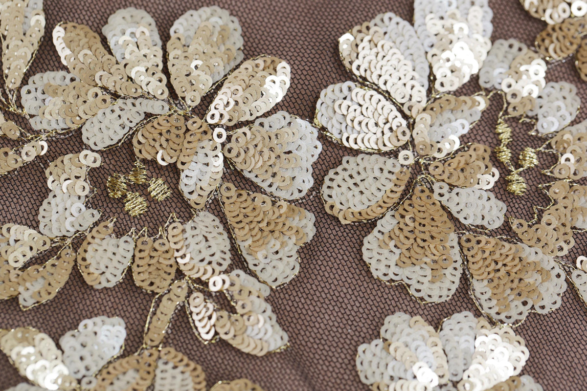 intricate gold and white sequin designs, including flowers and leaves, creating a visually striking and detailed pattern.
