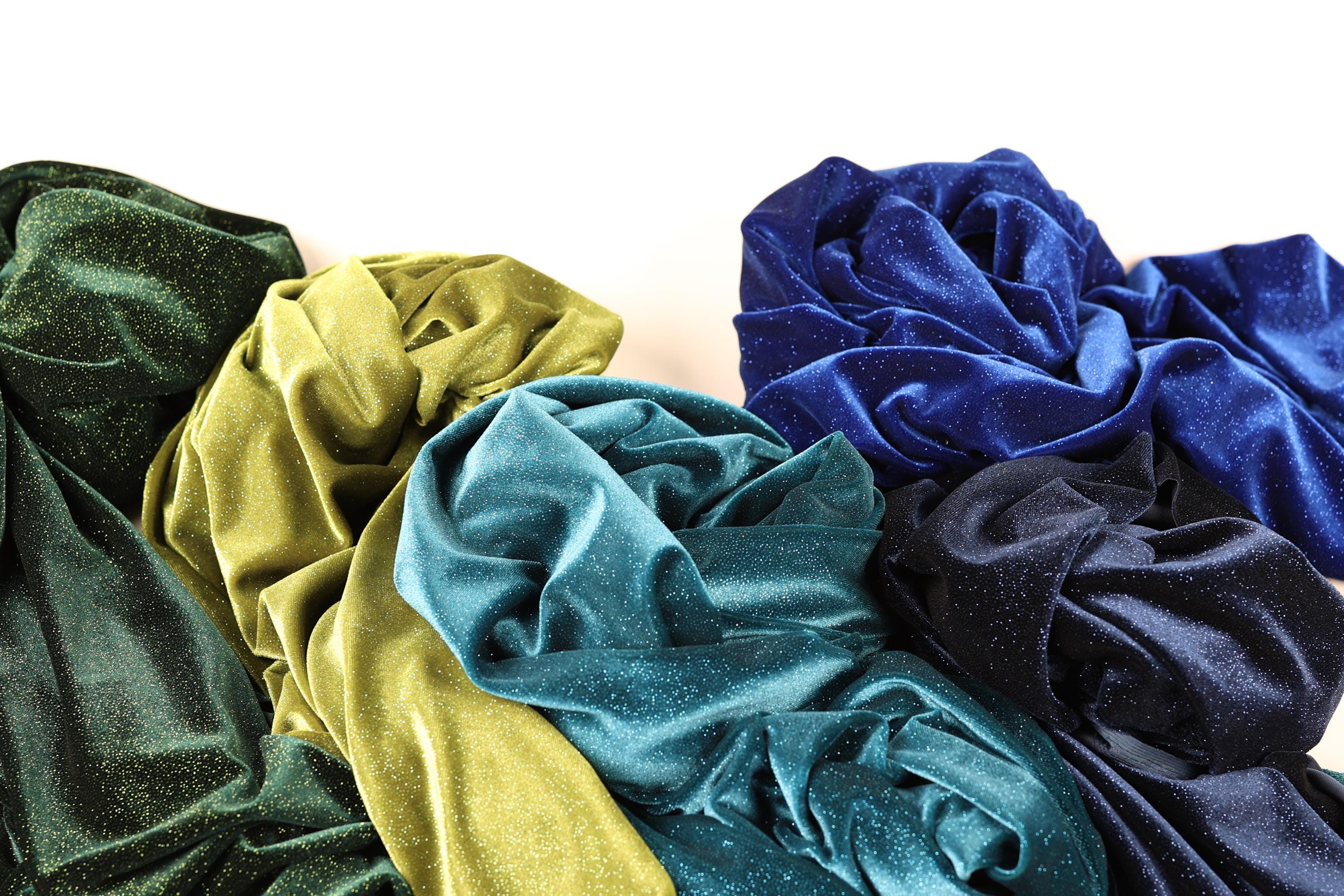 a variety of colorful, shiny fabric swatches arranged together, creating a visually appealing display.