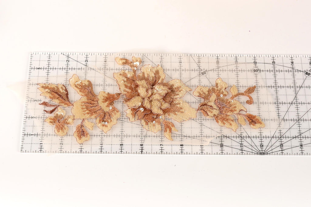 a clear ruler with a floral pattern of gold and brown flowers on it.