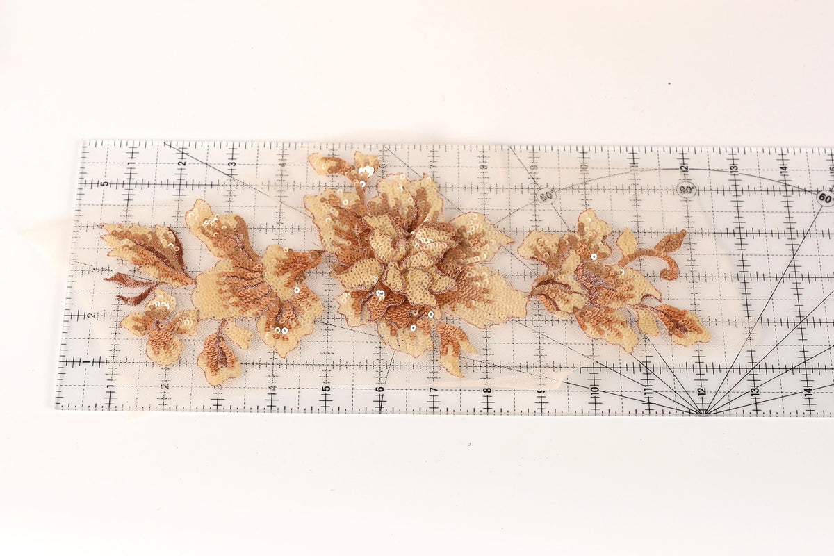 a clear ruler with a floral pattern of gold and brown flowers on it.