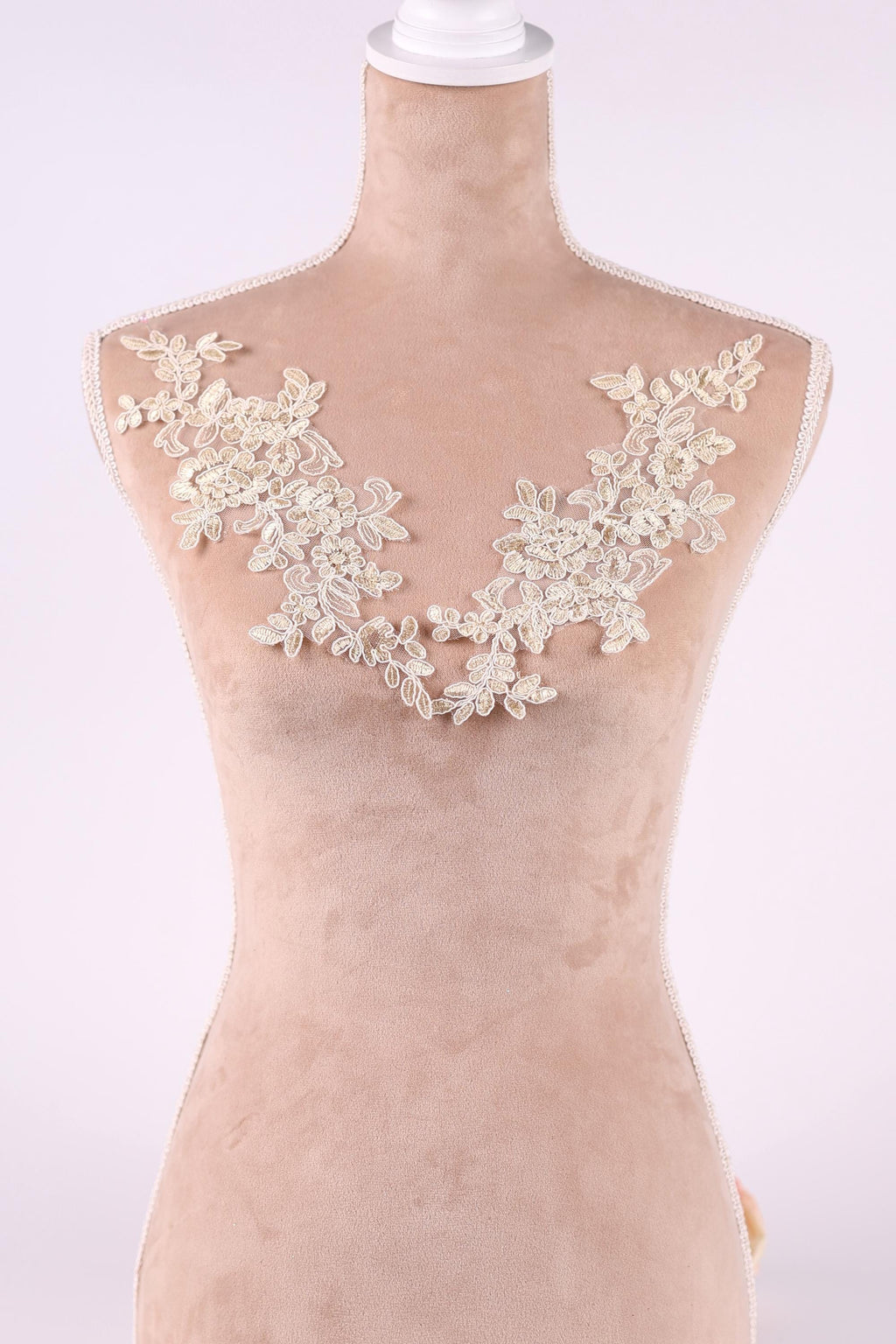 A mannequin wearing a dress with a delicate lace overlay on the bust area.