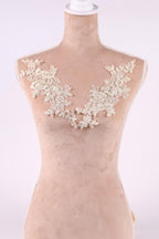 A mannequin wearing a dress with a delicate lace overlay on the bust area.