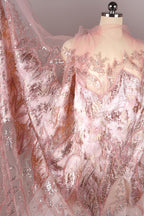 a mannequin wearing a pink and gold sequined dress with a sheer, flowing skirt.
