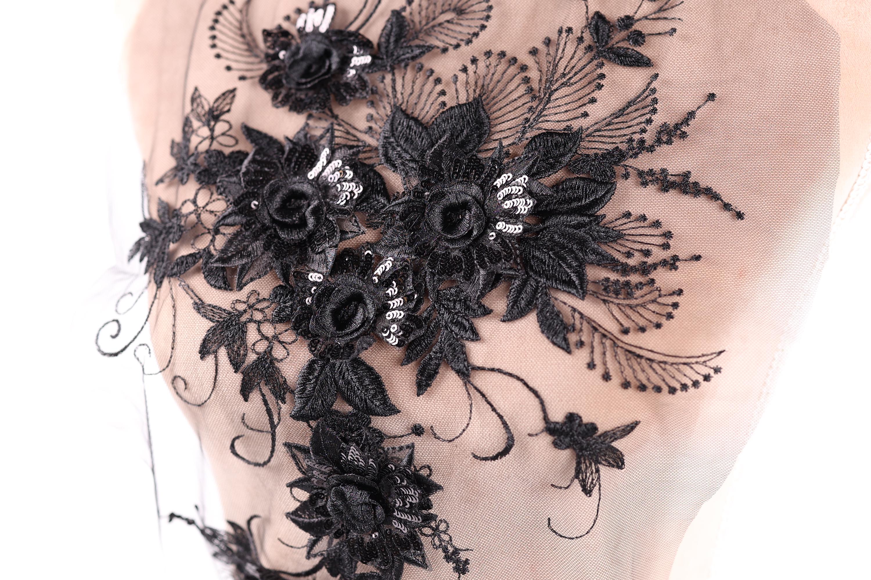 a close-up view of a delicate, intricate black lace design with floral elements.