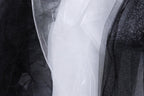 a close-up view of three different fabric textures, including black, white, and glittery black fabric.