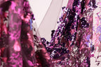 a close-up view of a fabric with a vibrant mix of purple and pink sequins, creating a visually striking and eye-catching pattern.