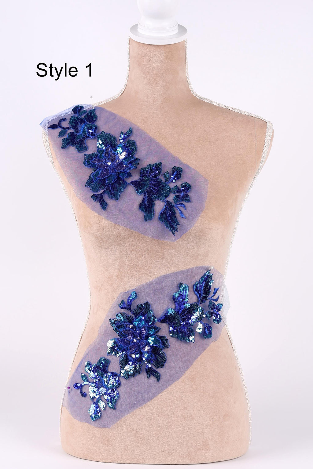 A mannequin with a beige body and a white head, wearing a purple and blue sequin design on its torso.