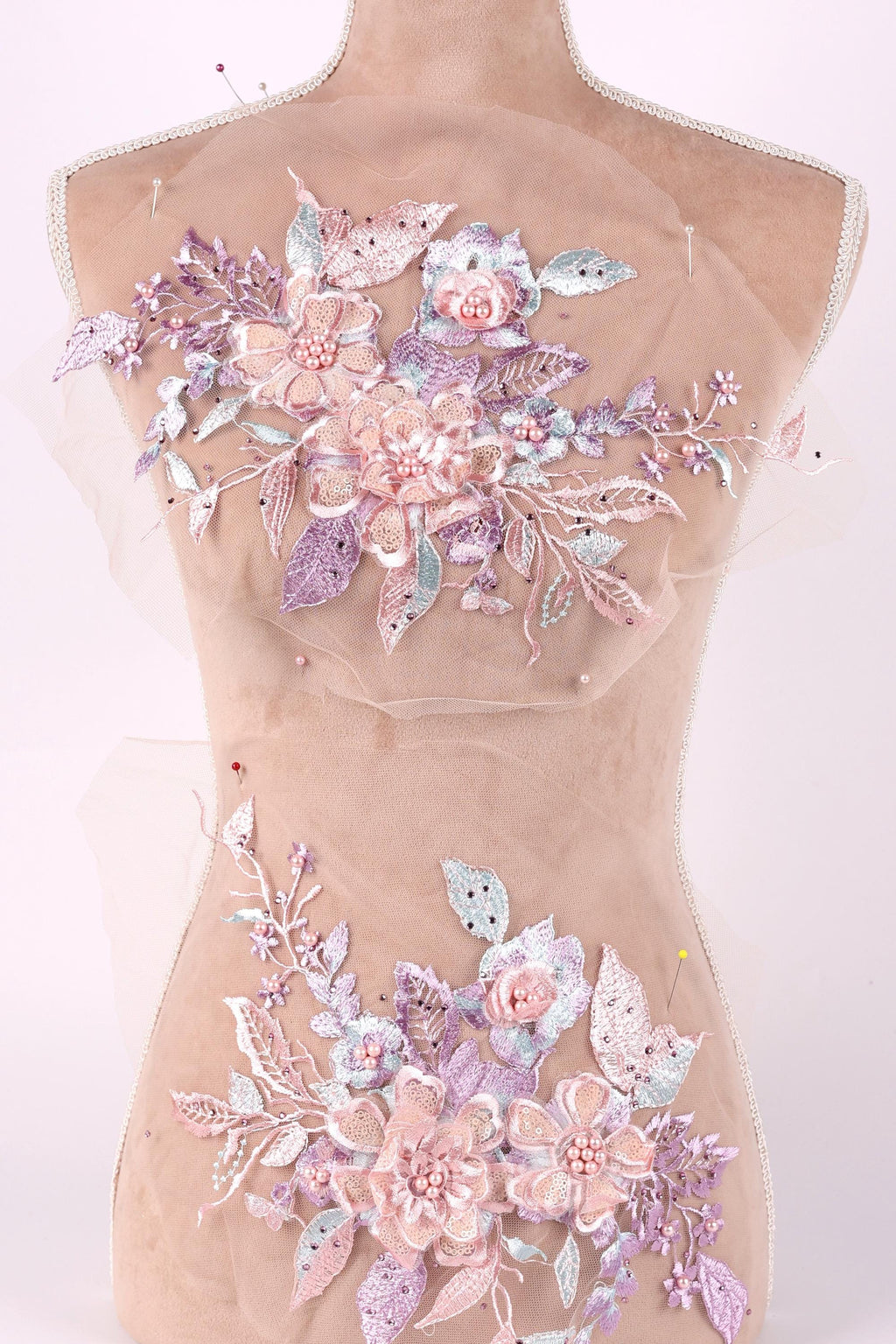 A mannequin torso with a decorative floral design on it, featuring a variety of pink and purple flowers and leaves.