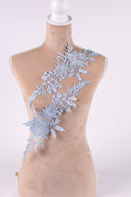 A mannequin wearing a light blue lace overlay on its torso.