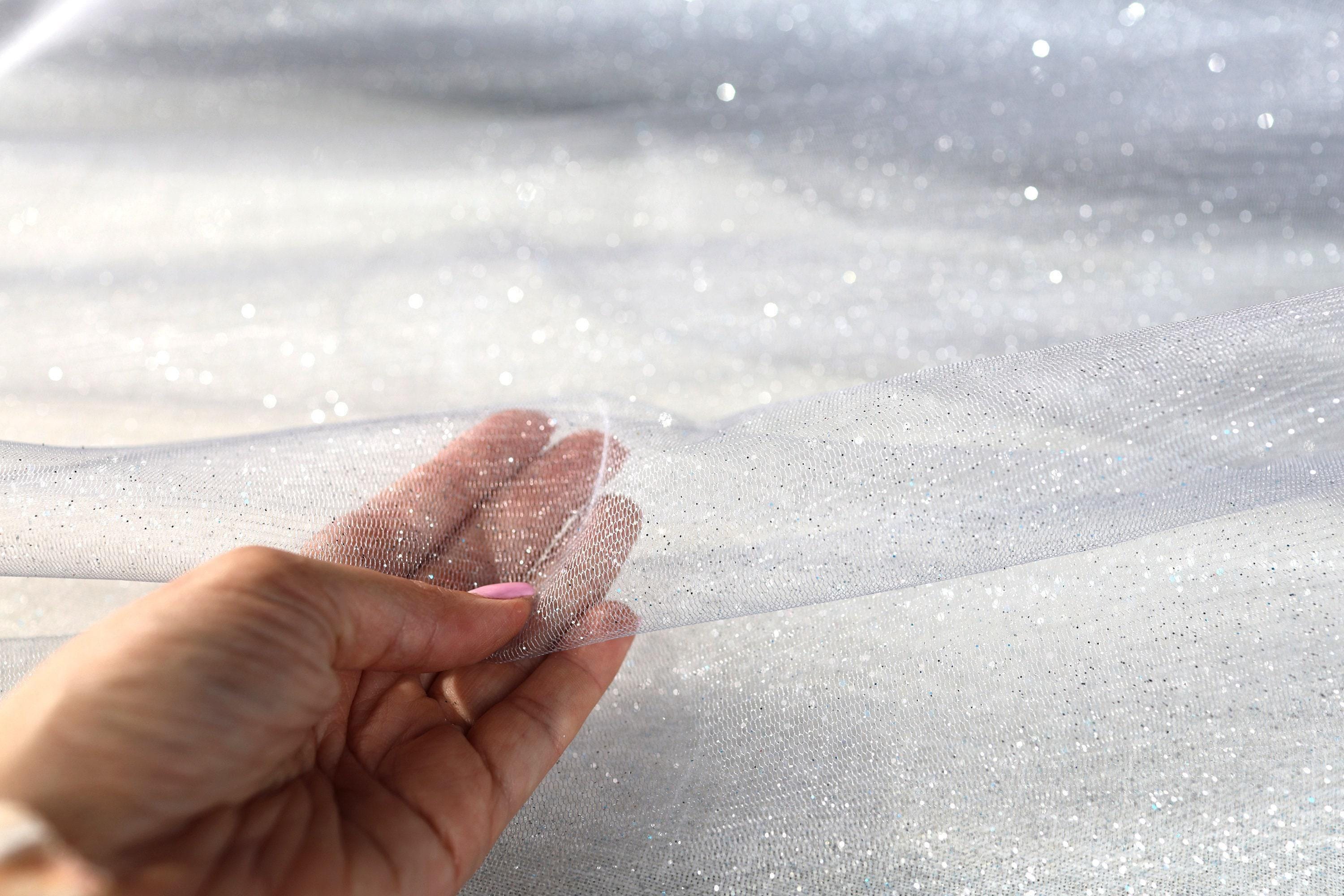 a person's hand holding a piece of clear material