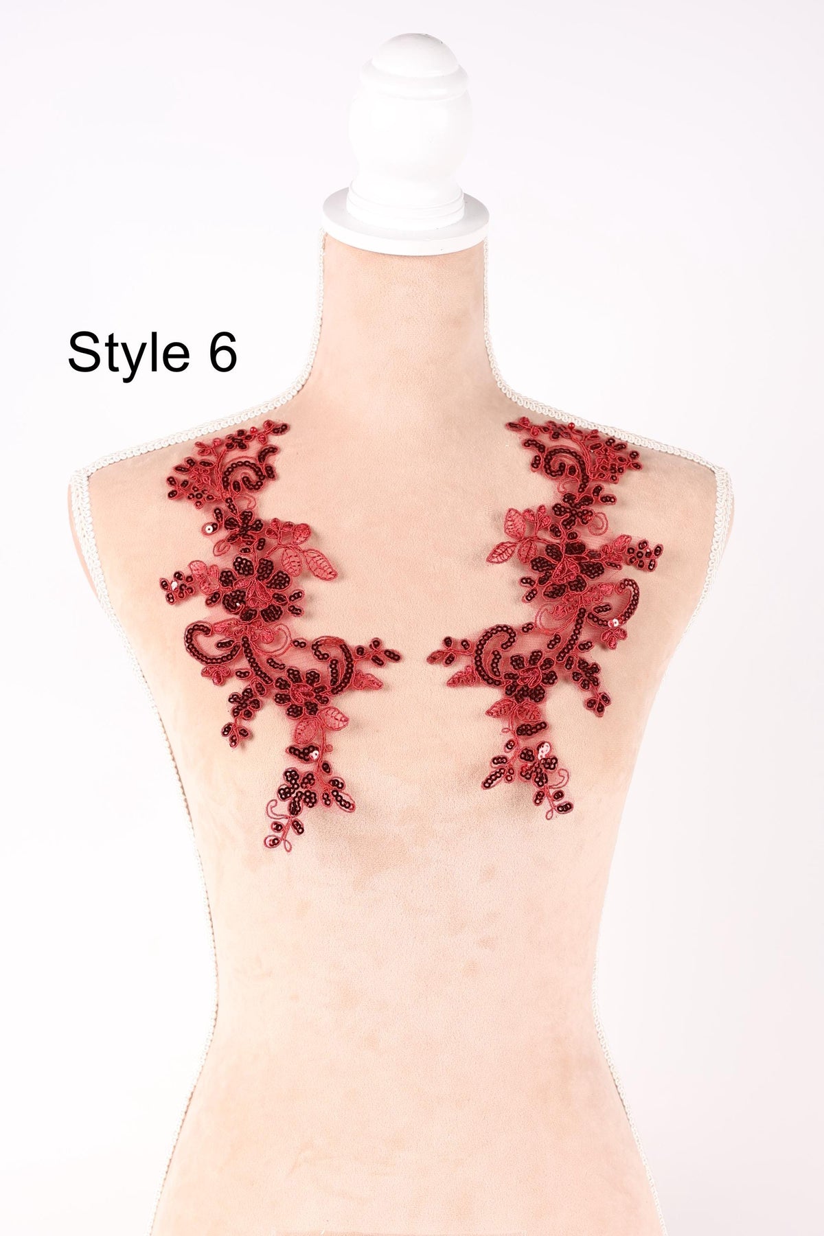 A mannequin with red floral embroidery on its bust area, displayed against a white background.