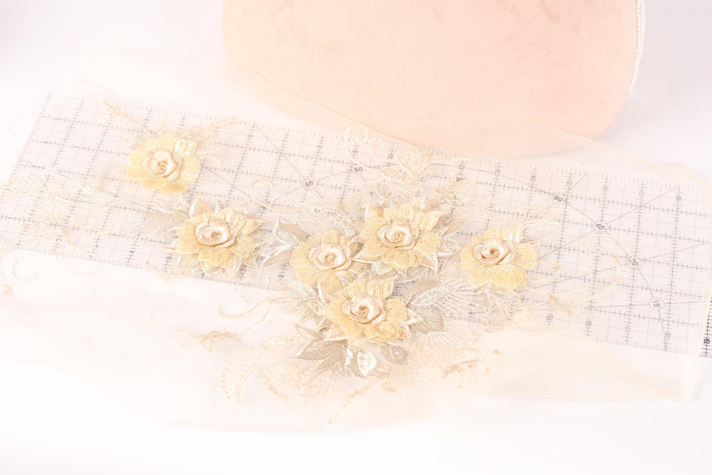 a delicate arrangement of yellow flowers on a white background, with a pink object in the background.