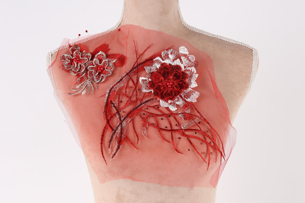 a mannequin with a red and white floral design on its bust, including a large red flower and smaller flowers with red and white petals.