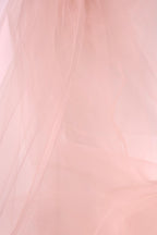 The image is a close-up of a soft, light pink fabric, possibly tulle, with a slightly wrinkled texture.
