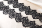 a close-up view of a delicate black lace fabric with intricate patterns and textures.