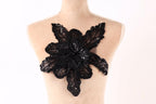 A mannequin wearing a dress with a large black sequined flower on the back.