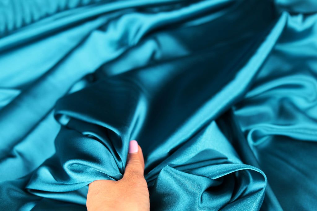 a person&#39;s hand on a blue cloth