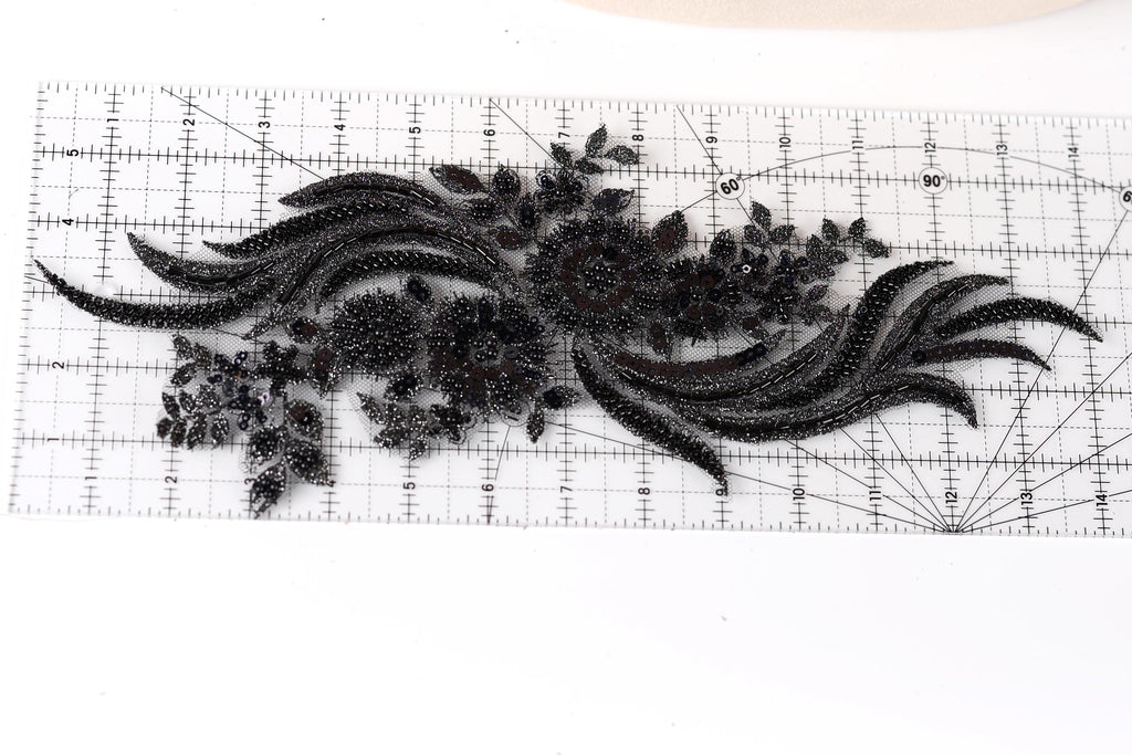 a close-up view of a black lace-like fabric with intricate floral designs.