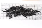 a close-up view of a black lace-like fabric with intricate floral designs.