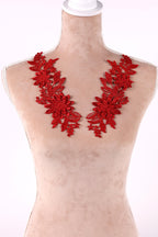 A mannequin wearing a red floral embroidered patch on the bust area.
