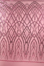 a pink fabric with a repeating pattern of black and pink lines and shapes, creating an intricate and visually striking design.
