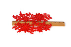 a pair of red flower-shaped embroidery pieces placed on a wooden ruler, which is used to measure the size of the flowers.