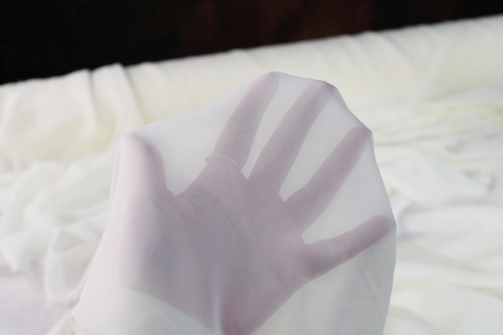 a close up of a white cloth with a hand on it
