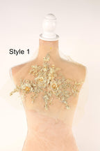 A mannequin with a decorative gold floral lace overlay on its bust.