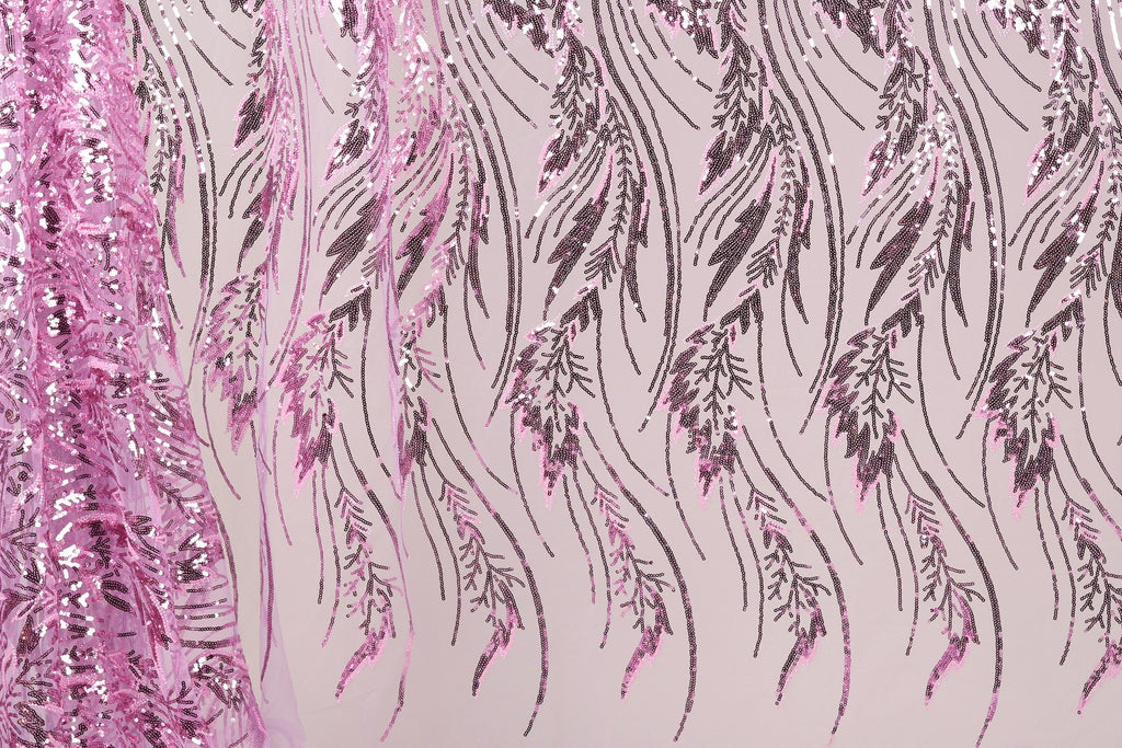 a close-up view of a fabric with a repeating pattern of pink and black sequin designs. The pattern consists of long, thin lines that create a flowing, feather-like appearance. The fabric appears to be made of a shiny, metallic material, which adds to the visual appeal of the design.
