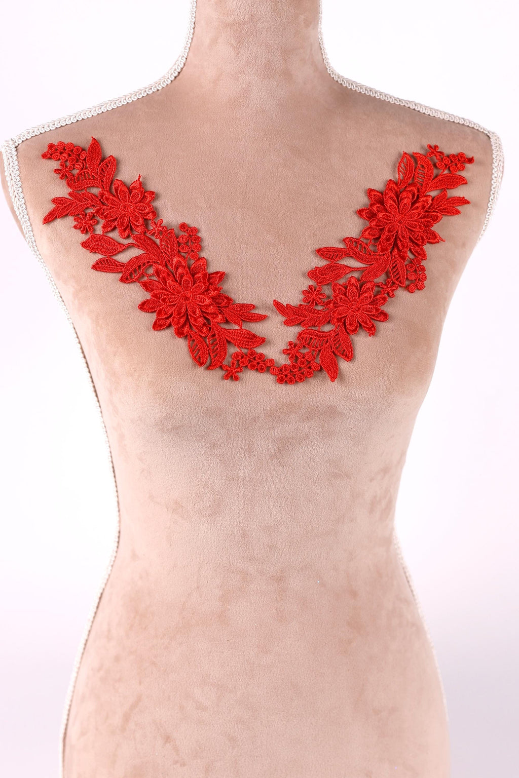 A mannequin torso with red floral embroidery on the bust area.