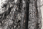 a close-up view of a black and grey sequined fabric, with intricate patterns and designs.