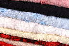 A close-up image of various colorful fabric swatches, including black, white, blue, red, and pink, arranged in a visually appealing manner.