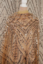 a close-up view of a sequined fabric with a pattern of gold and black sequins.