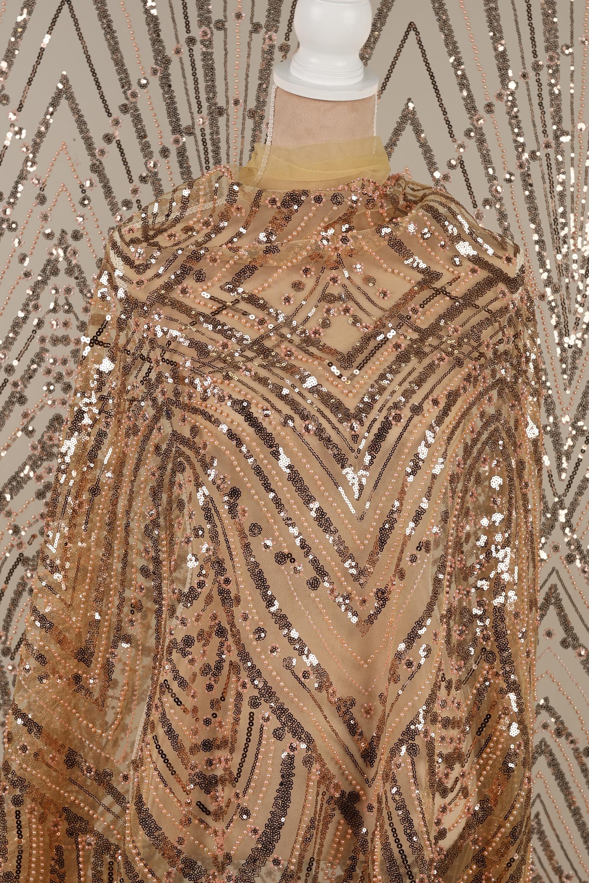 a close-up view of a sequined fabric with a pattern of gold and black sequins.