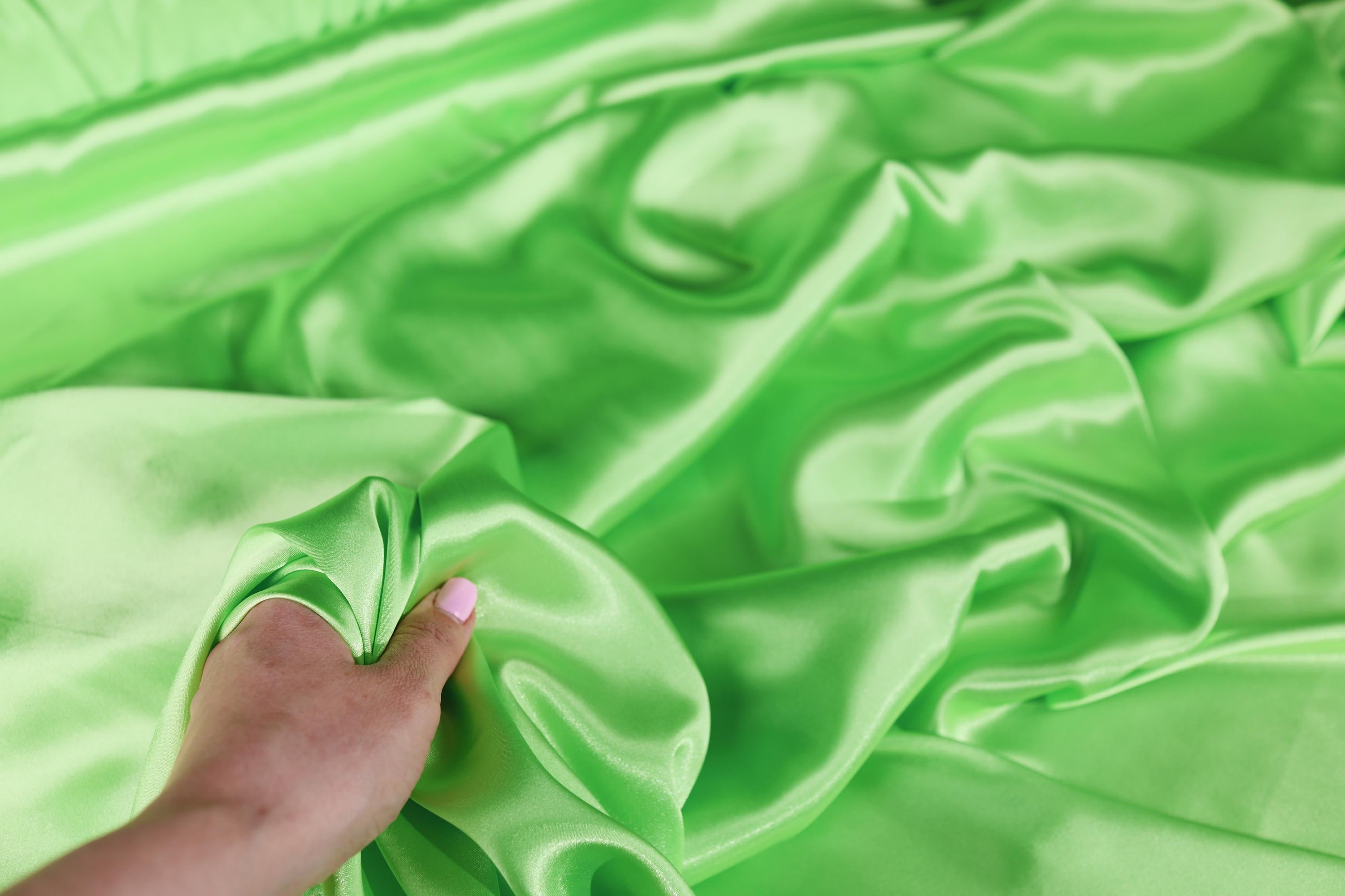 a person&#39;s hand on a green cloth