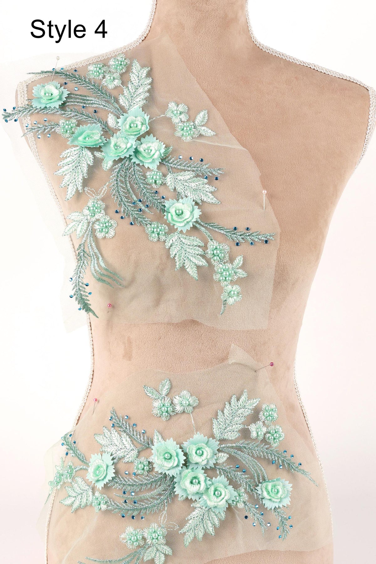 A mannequin wearing a dress with a floral pattern made of green and white fabric, featuring various flower and leaf designs.