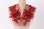 A mannequin wearing a red, sheer fabric with intricate floral embroidery.