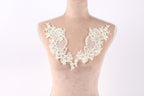 A mannequin with a white lace collar on its bust, featuring intricate floral and leaf designs.