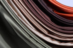 a close-up view of a collection of colorful satin fabric, with a gradient of colors ranging from light to dark brown.