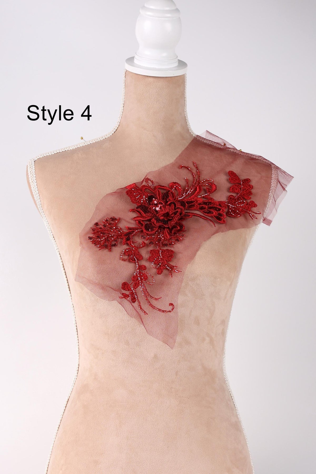 A mannequin with a red floral embellishment on its shoulder.