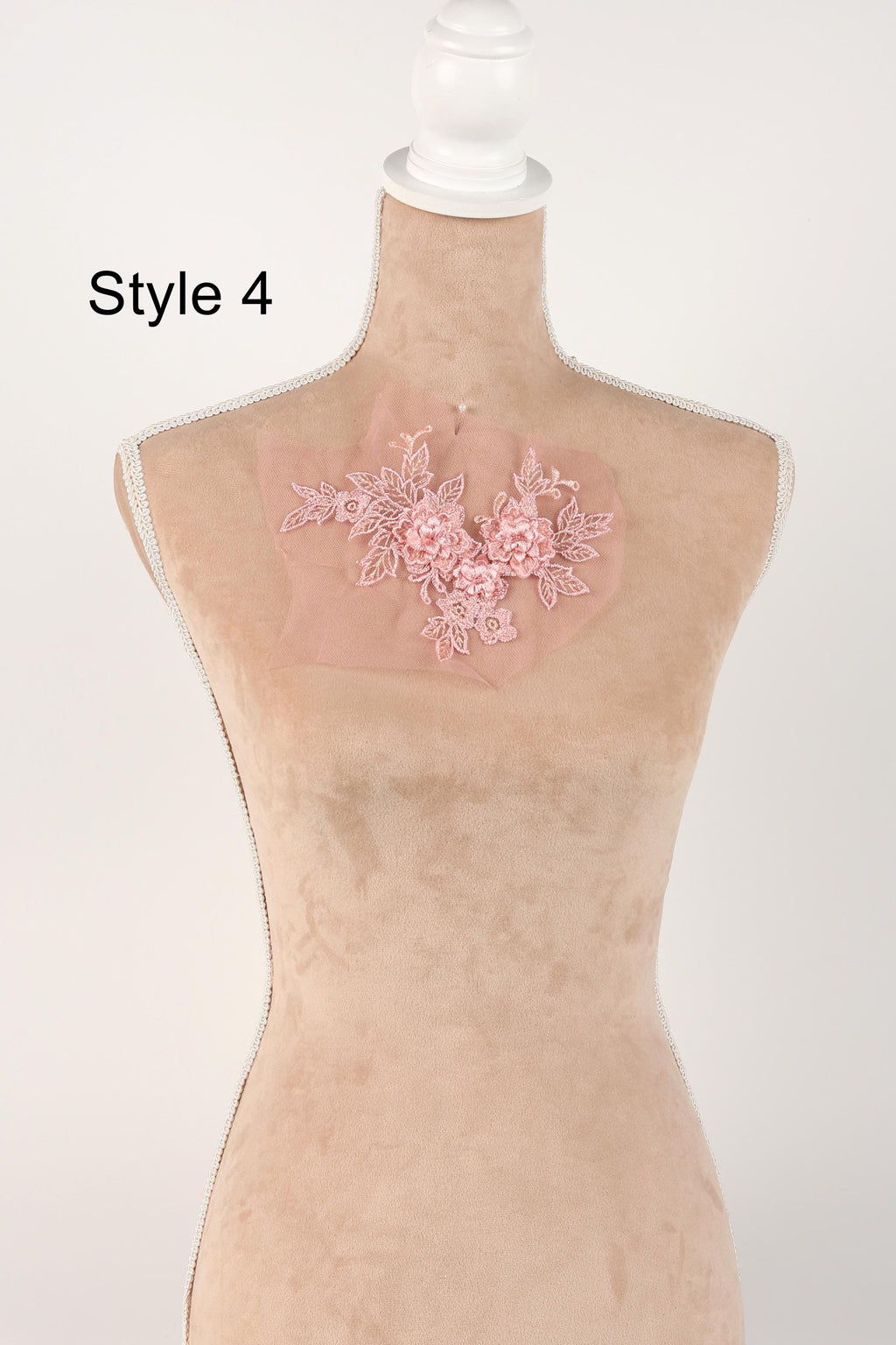 A mannequin with a pink floral embroidered on its bust, displayed against a white background.
