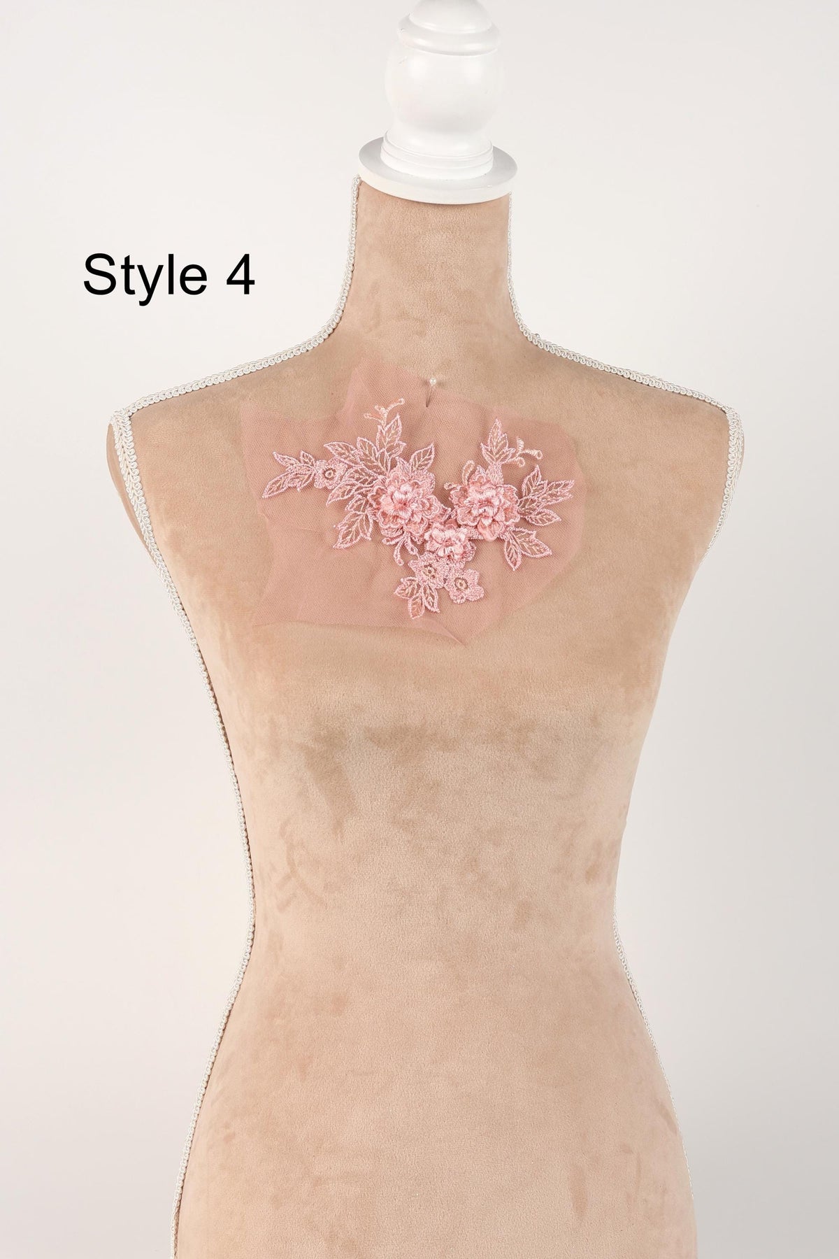A mannequin with a pink floral embroidered on its bust, displayed against a white background.
