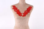A mannequin with red floral embroidery on its bust.