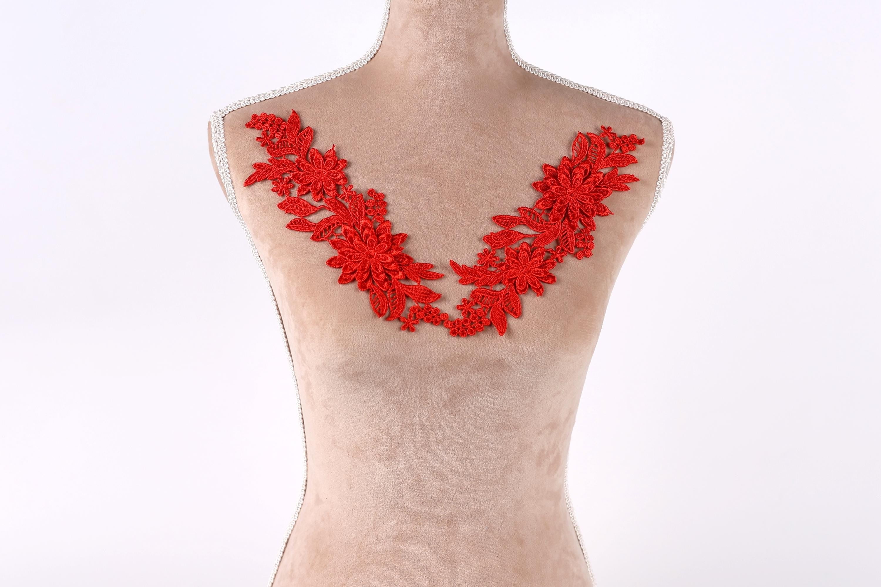 A mannequin with red floral embroidery on its bust.