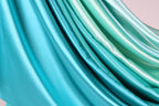a close-up view of a fabric with a gradient of blue and green colors, creating a visually appealing and textured appearance.