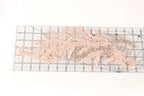 a clear ruler with a floral pattern of pink and beige beads on it.
